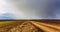 Timelapse. White clouds with rain move quickly across the blue sky over fields
