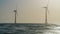 Timelapse Windmills in the Sea at Sunset. Silhouette of Wind Turbine Generating Electricity