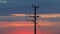 Timelapse of a wooden electricity distribution pole and cables at sunset. UK