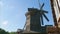 Timelapse of wooden mill with aircraft flying in blue sky on backround