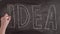 Timelapse word idea write on a chalkboard. On blackboard close-up draw word idea with chalk hand. oncept of the answer