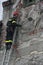 TIMISOARA, ROMANIA- 03.13.2011 A firefighter in full protective equipment climbed on a ladder removes pieces of wall that pose a d