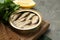 Tin can with tasty sprats served on grey textured table, closeup