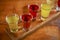 Tincture alcoholic in small shot glasses. Natural fruit alcohol drinks, shots served on a wooden table