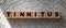 TINNITUS word written on wood block. TINNITUS text on wooden table for your desing,. Healthcare concept