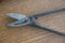 Tinsmith working tool .Close-up metal working scissors on a wooden surface, top view.