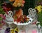 Tiny adorable table and chairs for tea party with flowers and berries.  Fairies in the garden