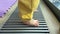 tiny baby barefoot legs in yellow trousers stepping colorful floor metal grill