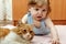 Tiny boy playing with cat house.