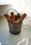 Tiny bucket with cinnamon sticks on rustic wooden background