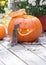 A tiny chipmunk peers into the eye of a pumpkin.