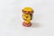 Tiny colorful wooden toy of an indian man face with designed hat and neck bracelet in a white background