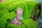 Tiny feet of a newborn baby, small fingers, wicker basket with green knitted scarf