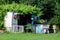 Tiny garden shed converted into rustic urban garden retreat filled with retro vintage elements covered with vines and crawler