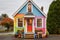 a tiny house with a bold, colorful front door on a plain background