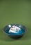 Tiny kid toy polar bear floating on cheese on a plate in blue water