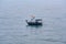 Tiny little Vietnamese fisherboat with flag on Sea on misty day