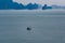 Tiny little Vietnamese fisherboat on sea in Ha Long Bay on misty day