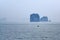 Tiny little Vietnamese fisherboat on sea in Halong Bay on misty day