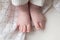 Tiny newborn baby feet on white blanket