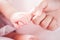 Tiny newborn baby hand holding mother finger with love