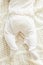 Tiny newborn babys feet in spotted romper suit on woolen blanket