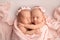 Tiny newborn twin girls. A newborn twins sleeps next to his sister.