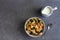 Tiny pancake cereal with blueberries and colored candies in a bowl on a gray background