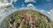 tiny planet in sky with clouds overlooking old town, urban development.