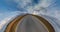 tiny planet transformation with curvature of space among fields on gravel road in sunny day with sky and fluffy clouds