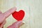 Tiny red heart held by women\'s fingers