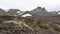 Tiny silhouettes of people are visible on the hiking trail in the valley.