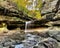 Tiny waterfall formed as stream tumbles over a stone ledge into a rocky canyon