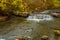 Tiny waterfall under autumn foliage