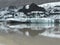 Tip of SÃ³lheimajÃ¶kull glacier in iceland, with dark layers of soil, reflected in water