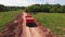 Tip truck with cargo in workbody drives along rural road