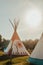 Tipi house in the forest against the background of trees, camping, village in the forest, camping. Indian teepee house at sunset