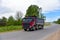 Tipper Dump Truck transported sand from the quarry on driving along highway. Modern Heavy Duty Dump Truck with unloads goods by