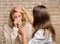 Tips how to get rid of cold. Woman feels badly ill sneezing. Girl in scarf hold tissue while doctor examine her