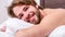 Tips on how to wake up feeling fresh and energetic. Morning routine tips to feel good all day. Man handsome guy lay in