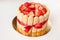 tiramisu cake with strawberries, ladyfingers, mascarpone and red bow-tape isolated on white