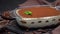 Tiramisu dessert in glass baking dish and pieces of chocolate bar on concrete background