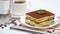 Tiramisu dessert portion, mocha coffee maker and cup of fresh espresso coffee on white background