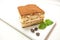 Tiramisu, traditional Italian dessert on a white plate. Close up.