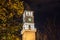 Tirana, Albania - March 16 2021: Clock Tower close-up behind trees night shot