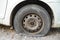 Tire leak, close up wheel of old white vintage car. Car wheel flat tire on the road. Deflated the tyre of an old car next to a
