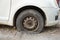 Tire leak, close up wheel of old white vintage car. Car wheel flat tire on the road. Deflated the tyre of an old car next to a