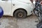 Tire leak, close up wheel of old white vintage car. Car wheel flat tire on the road. Deflated the tyre of an old car next to a