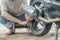 Tire Repairman uses a tire scraping tool to remove motorcycle tires