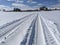 Tire Tracks Across Snowy Field